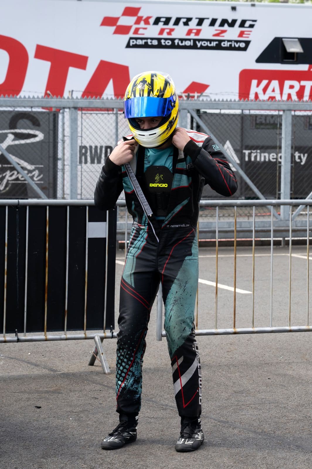 Donát adjusting his helmet in the paddock, Třinec